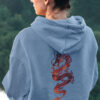 girl in blue hoodie with red dragon art