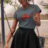woman in grey shirt with dragon art on swing