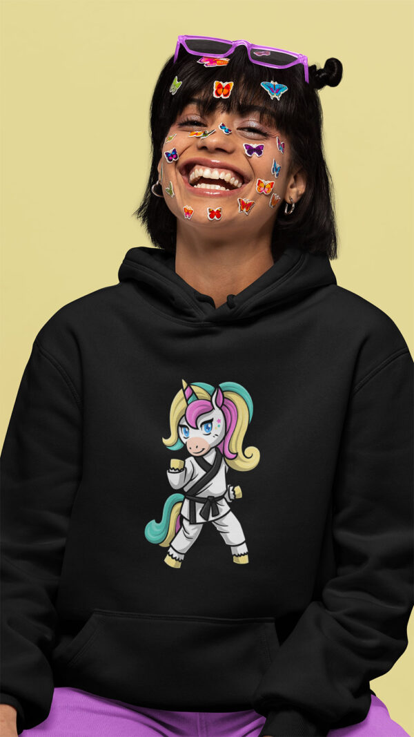 woman wearing black hoodie with karate unicorn art and stickers on her face
