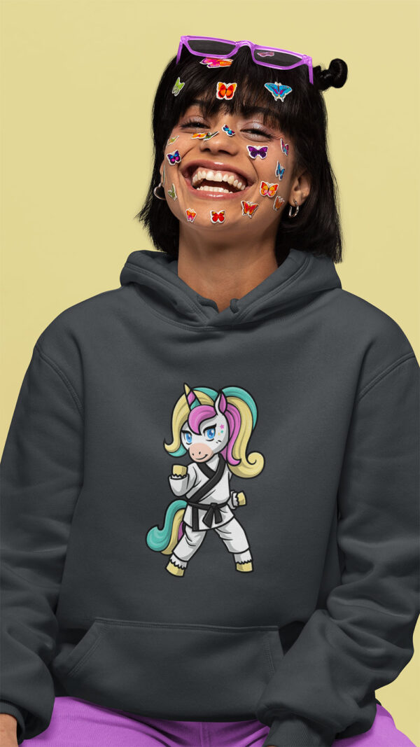 woman wearing gray hoodie with karate unicorn art and stickers on her face
