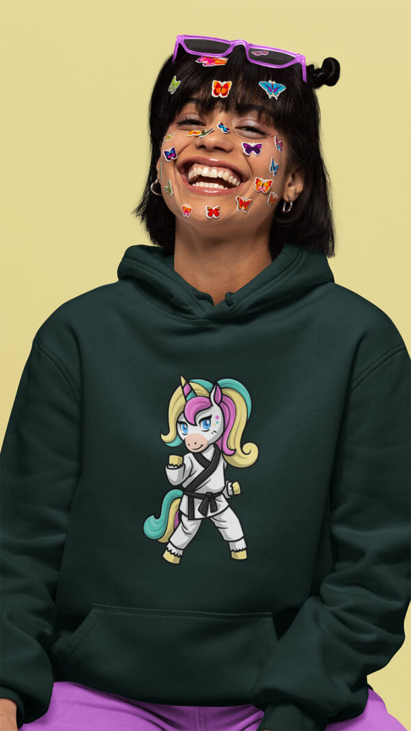woman wearing green hoodie with karate unicorn art and stickers on her face