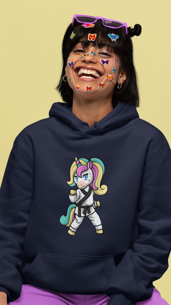 woman wearing dark blue hoodie with karate unicorn art and stickers on her face