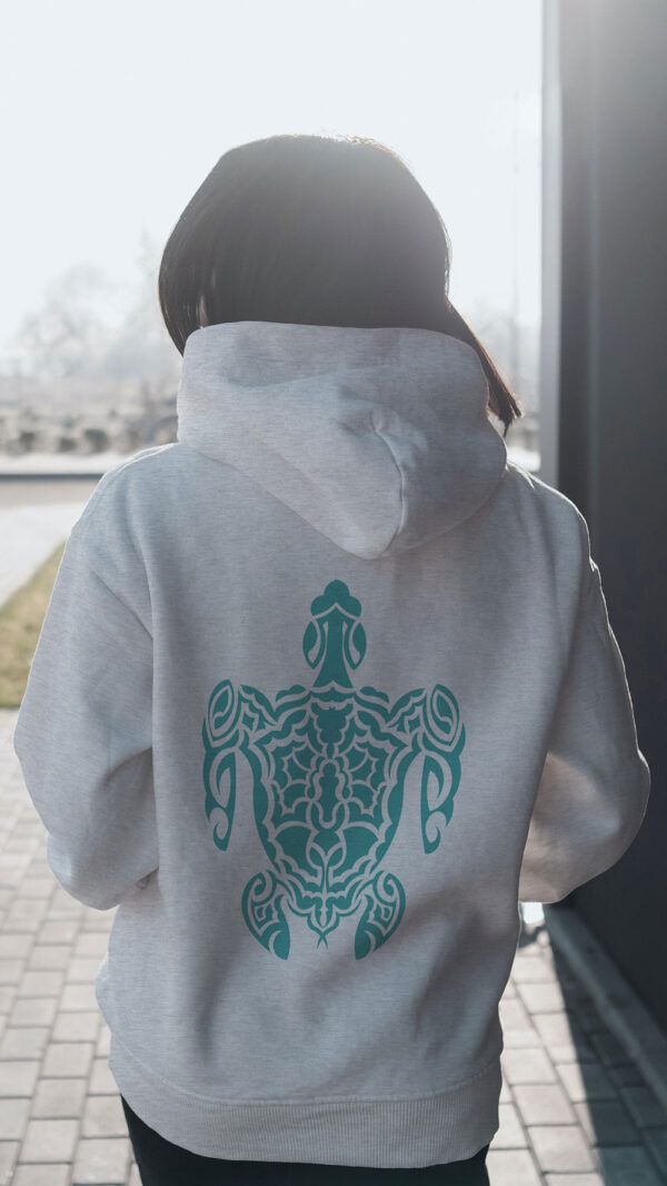 woman in white hoodie with green turtle art