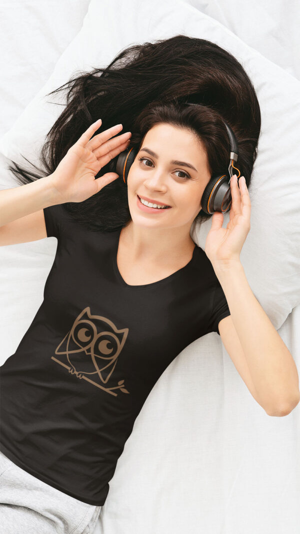 woman in black shirt with brown owl art with headphones